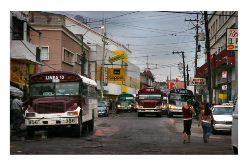 Two young women walk by a busy bus stop on the corner of Mariscal and Ugarte in downtown Cd. Juárez where many maquila workers commute to and from work. A majority of missing and murdered women are maquila workers who are last seen by their coworkers on their way home September 4, 2006. Photo by Christ Chavez 